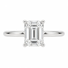 Load image into Gallery viewer, An emerald-cut diamond solitaire ring in a polished silver-colored metal setting, shown against a plain white background.