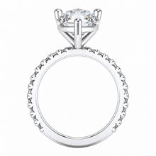 Load image into Gallery viewer, A silver-toned solitaire engagement ring with a round brilliant-cut clear center stone and a shank paved with small round stones, shown on a plain white background.