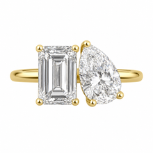Load image into Gallery viewer, A yellow gold ring featuring a rectangular emerald-cut diamond on the left and a pear-cut diamond on the right, set on a clean white background.