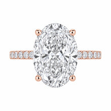 Load image into Gallery viewer, An oval-cut diamond engagement ring in a rose gold setting with a pavé band, shown on a solid white background.
