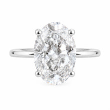 Load image into Gallery viewer, An oval-cut diamond ring with a polished silver-colored band, set against a plain white background.
