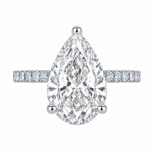 Load image into Gallery viewer, A pear-cut diamond engagement ring with a pavé band, set in a silver-colored metal on a plain white background.
