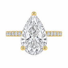 Load image into Gallery viewer, A pear-cut diamond engagement ring in yellow gold, featuring a large central diamond and smaller diamonds set along the shoulders of a gold band, shown on a plain white background.
