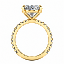 Load image into Gallery viewer, A yellow gold ring featuring a large radiant cut clear gemstone in a prong setting, with a pavé band adorned with small round-cut stones, shown on a plain white background.
